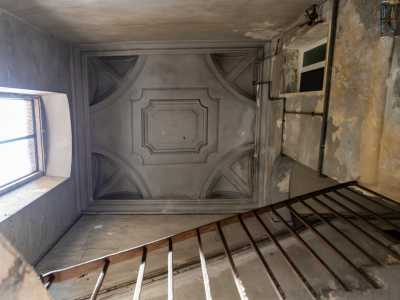 Superati i primi gradini e alzando lo sguardo possiamo scoprire la prima meraviglia del palazzo: un ampio finestrone illumina lo stupefacente soffitto rettangolare impreziosito da stucchi e delimitato da una cornice perimetrale